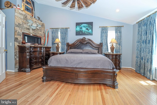 bedroom with lofted ceiling, wood-type flooring, and baseboards