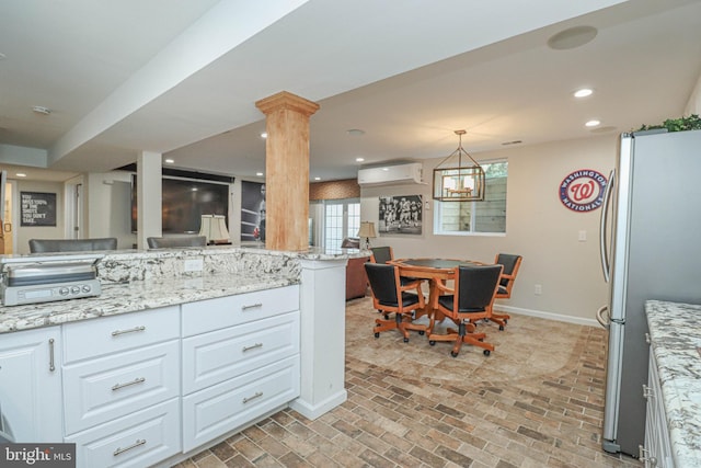 kitchen with recessed lighting, freestanding refrigerator, white cabinets, a wall mounted air conditioner, and baseboards