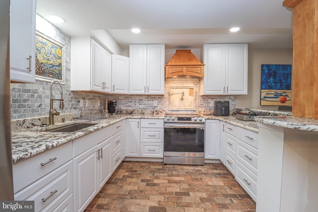 kitchen with recessed lighting, premium range hood, a sink, and electric range