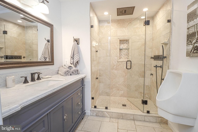 full bath featuring a stall shower, vanity, stone tile floors, and recessed lighting