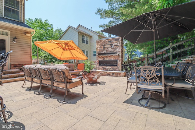 view of patio featuring outdoor dining area and an outdoor living space with a fireplace