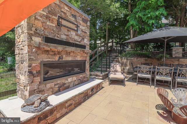 view of patio / terrace with an outdoor stone fireplace and outdoor dining space