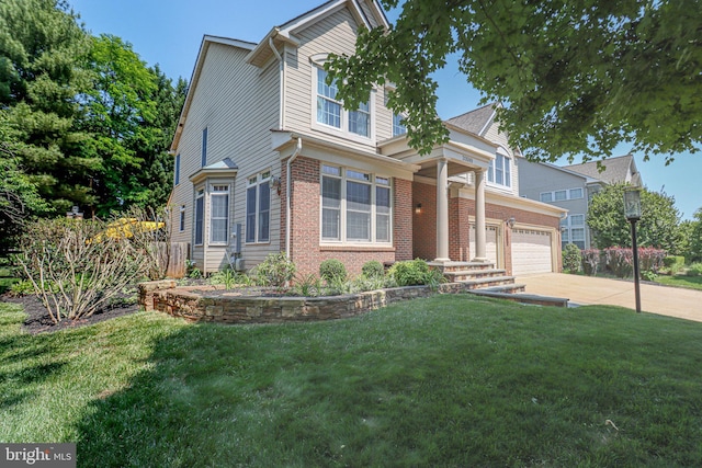view of front of property featuring a garage, driveway, brick siding, and a front yard