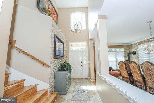entrance foyer featuring stairs, a high ceiling, and a notable chandelier