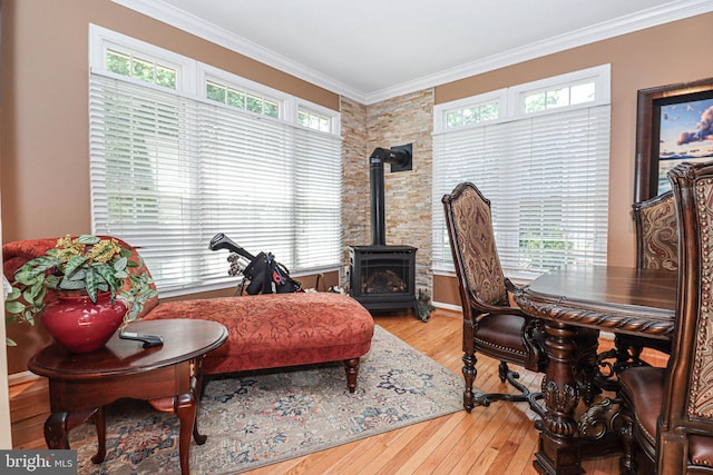 interior space featuring a wood stove, light wood-style floors, plenty of natural light, and crown molding
