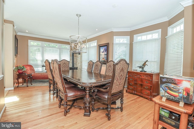 dining space featuring ornamental molding, light wood-type flooring, a notable chandelier, and baseboards