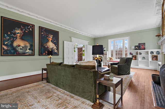 living room with crown molding, baseboards, and wood finished floors