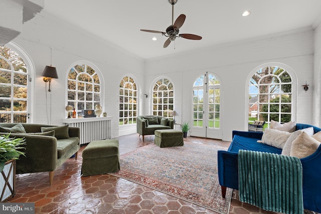 sunroom with french doors, stone finish floor, ornamental molding, and recessed lighting