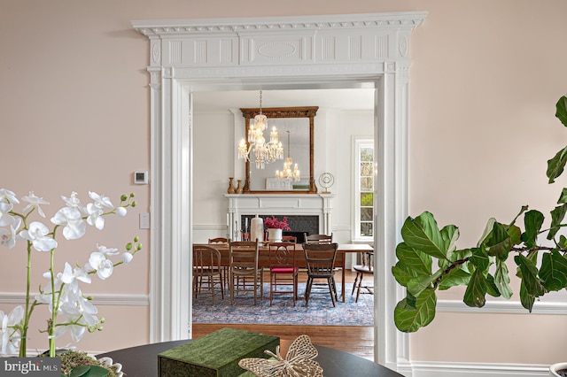 dining room featuring a chandelier, wood finished floors, and a fireplace