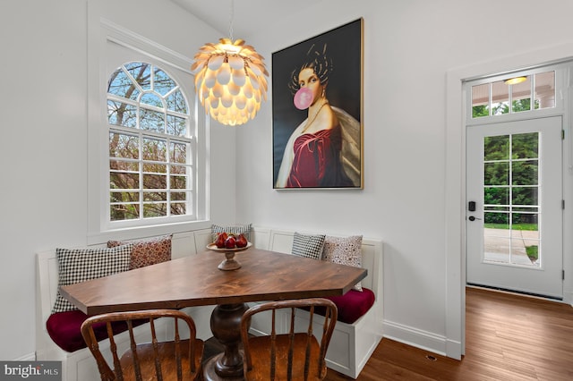 dining space featuring breakfast area, wood finished floors, baseboards, and plenty of natural light