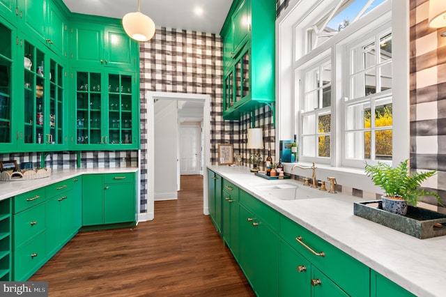 kitchen featuring light countertops, a sink, hanging light fixtures, decorative backsplash, and dark wood-style floors