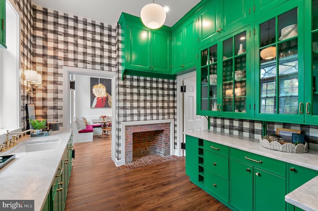 kitchen with a fireplace, dark wood-style flooring, and a sink