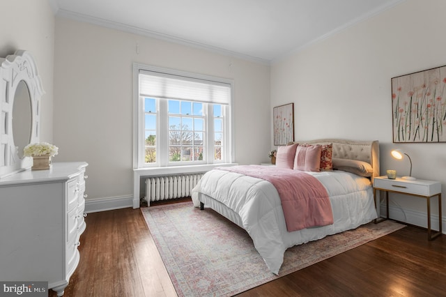 bedroom with radiator heating unit, hardwood / wood-style floors, baseboards, and crown molding