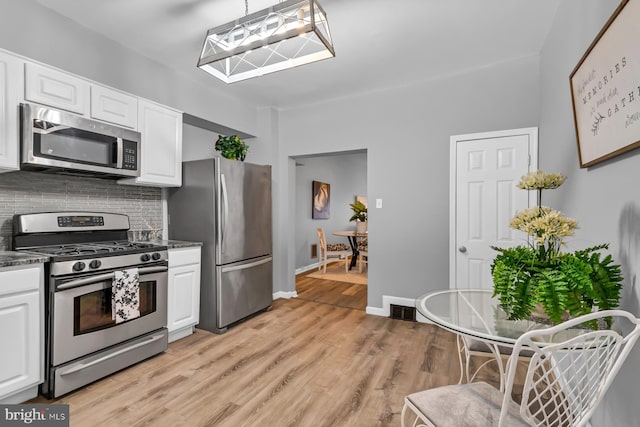 kitchen with dark countertops, white cabinetry, visible vents, and appliances with stainless steel finishes