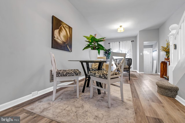 dining area with light wood-type flooring and baseboards