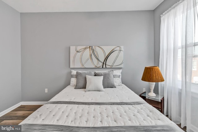 bedroom featuring baseboards and dark wood-type flooring