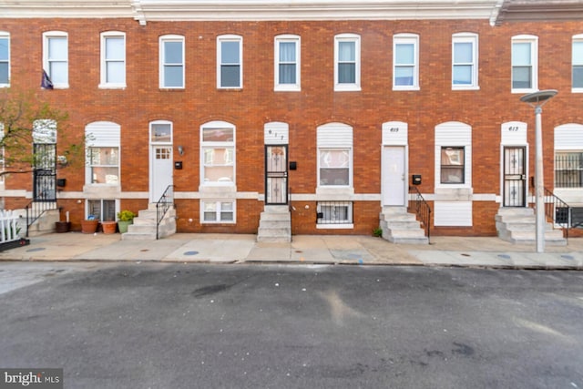 townhome / multi-family property with entry steps and brick siding