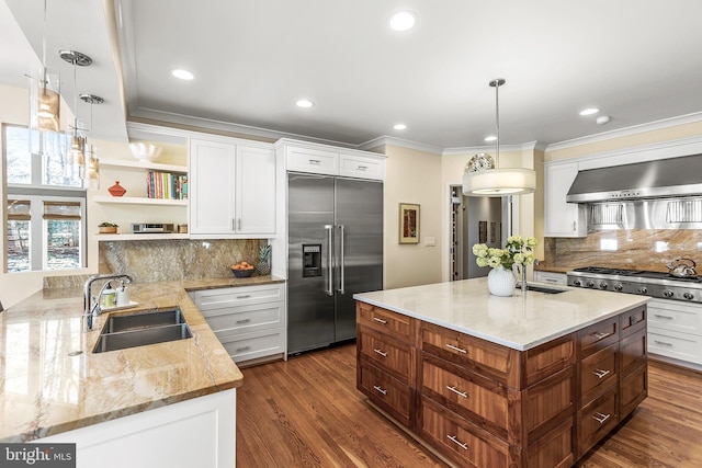 kitchen with stainless steel appliances, a sink, white cabinets, wall chimney exhaust hood, and open shelves