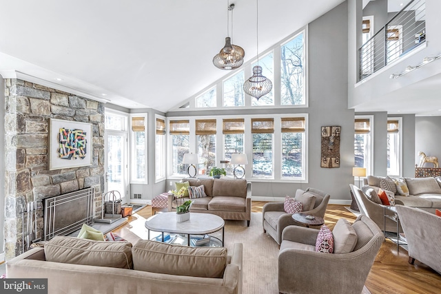 living area featuring a high ceiling, a fireplace, and baseboards