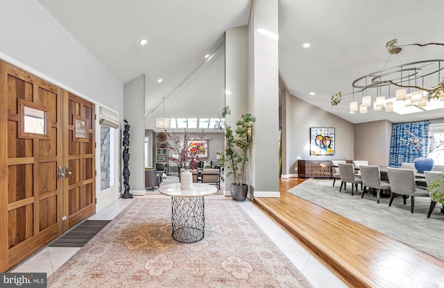 entrance foyer with baseboards, a chandelier, light wood-type flooring, high vaulted ceiling, and recessed lighting