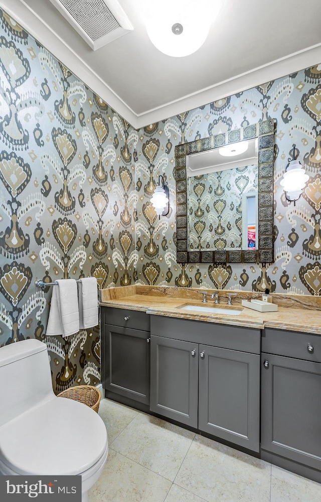 bathroom featuring toilet, wallpapered walls, visible vents, and vanity