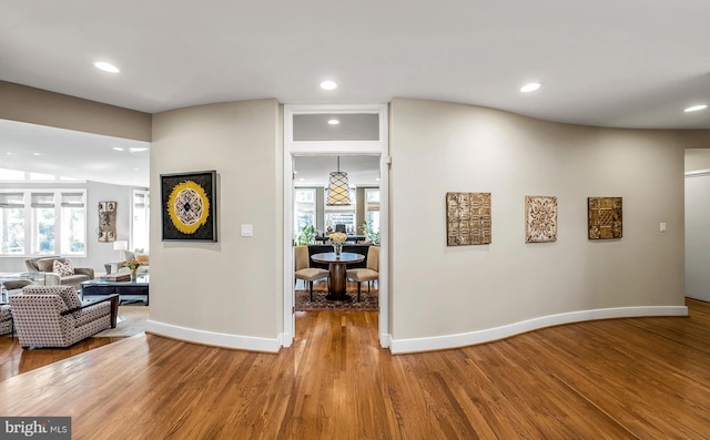 corridor featuring recessed lighting, baseboards, and wood finished floors