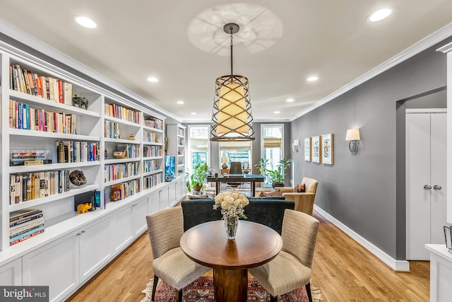 dining space with light wood-style floors, crown molding, and recessed lighting