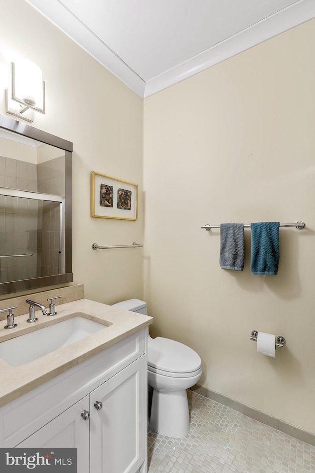 bathroom featuring a stall shower, toilet, tile patterned floors, crown molding, and vanity