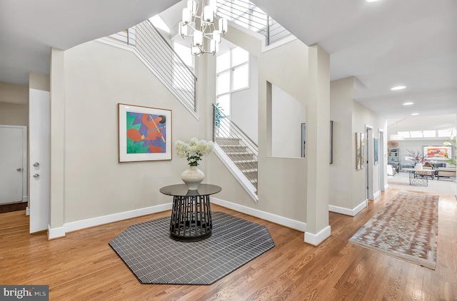 foyer with stairs, plenty of natural light, baseboards, and wood finished floors