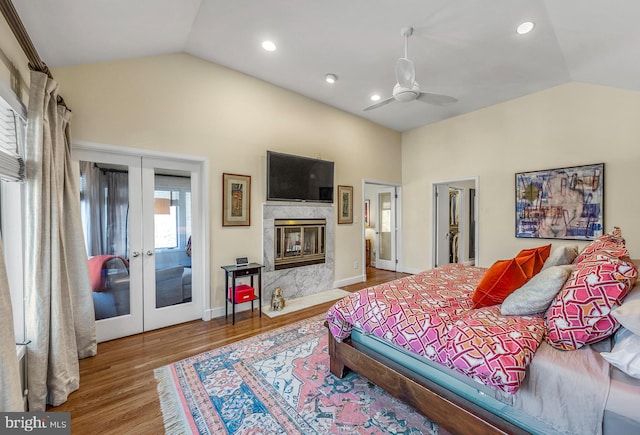 bedroom featuring a high end fireplace, vaulted ceiling, and french doors