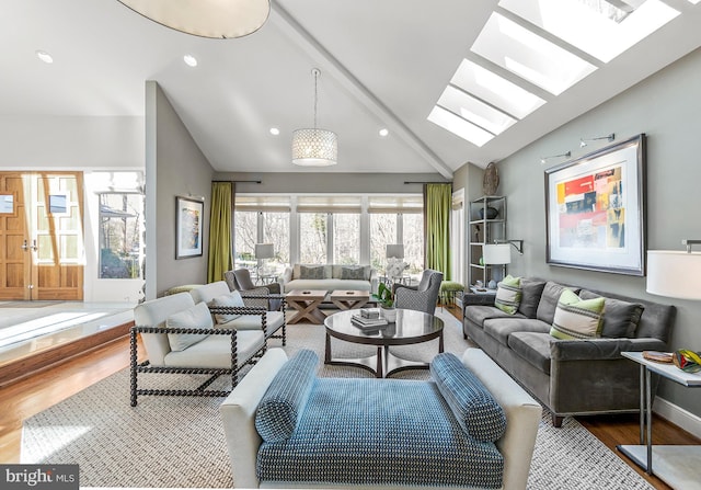 living room featuring baseboards, lofted ceiling with skylight, wood finished floors, and recessed lighting