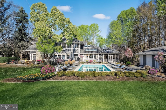 exterior space featuring a patio, a lawn, and a sunroom