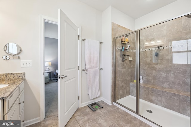 bathroom featuring a shower stall, vanity, baseboards, and tile patterned floors