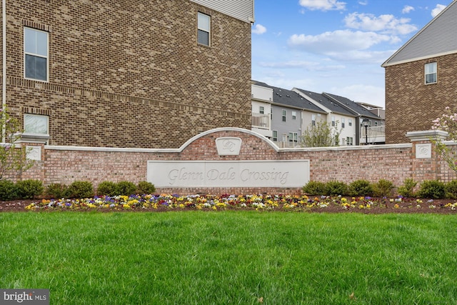 community / neighborhood sign with a residential view and a lawn