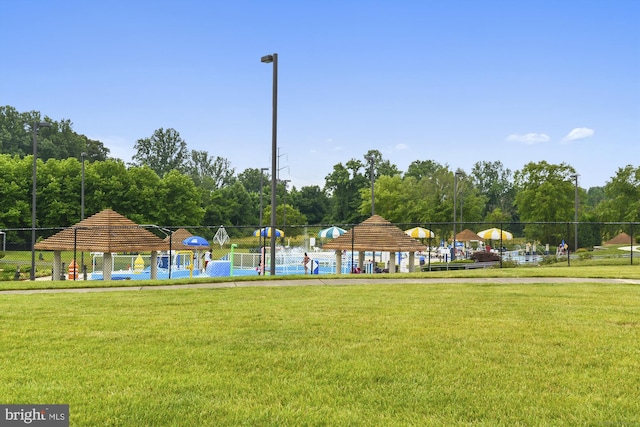 view of community featuring a yard, fence, and a gazebo