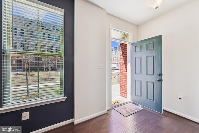 foyer featuring baseboards and wood finished floors