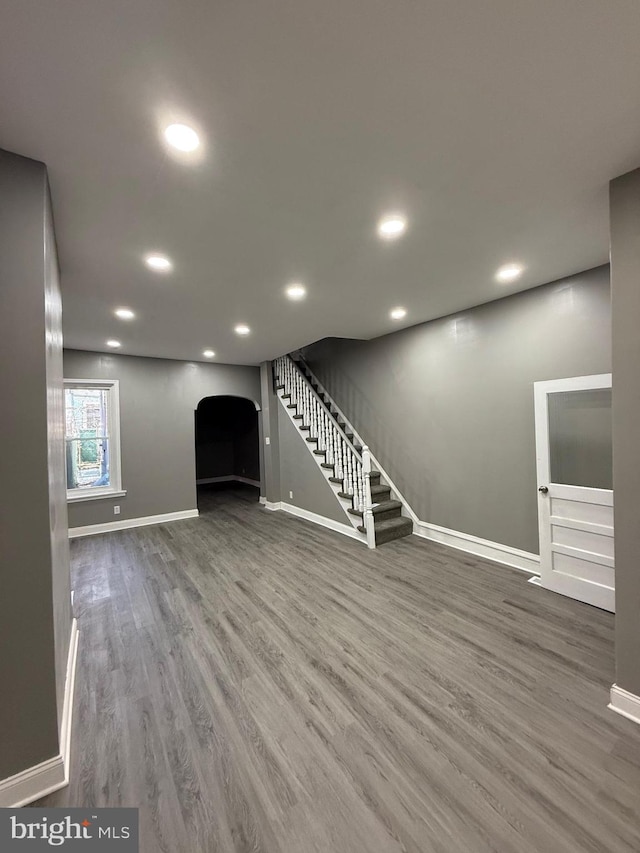 below grade area featuring stairs, baseboards, and wood finished floors