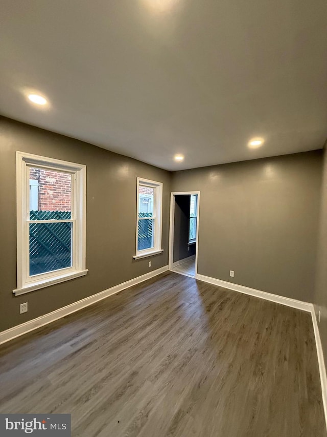 empty room with recessed lighting, baseboards, and wood finished floors