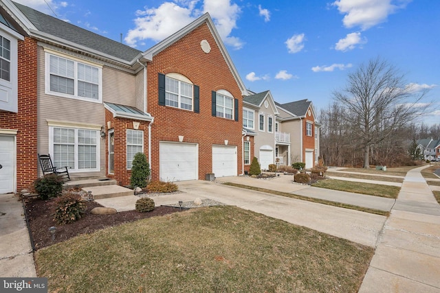 townhome / multi-family property featuring driveway, a garage, a residential view, and brick siding