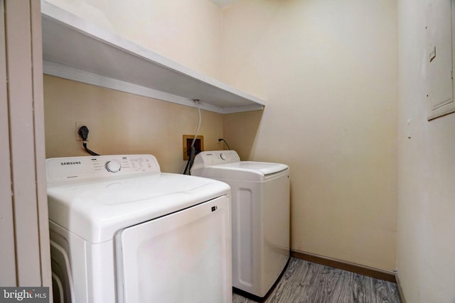 washroom featuring washing machine and dryer, laundry area, and wood finished floors