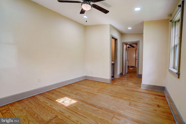 empty room featuring light wood-style flooring, baseboards, a ceiling fan, and recessed lighting