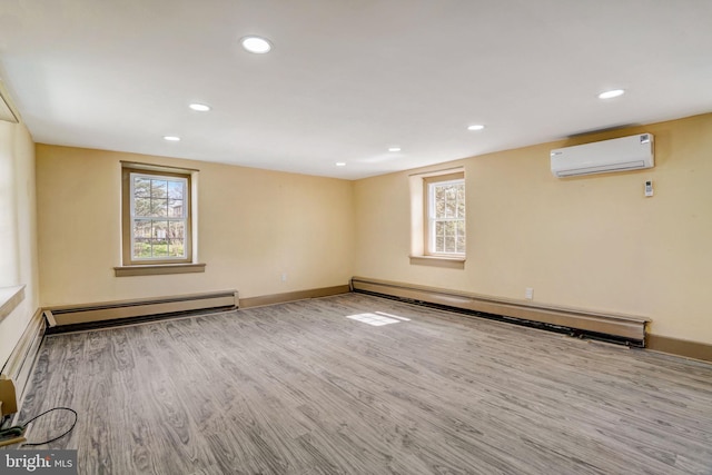 interior space with recessed lighting, an AC wall unit, baseboard heating, and wood finished floors