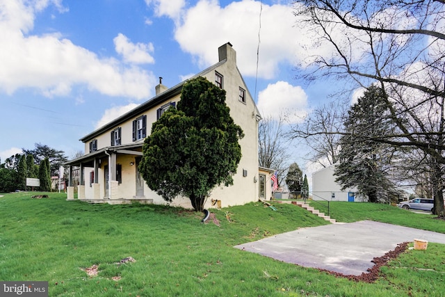 view of property exterior with a lawn, a chimney, and stucco siding