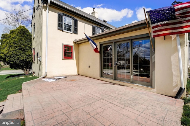 rear view of house featuring a patio and stucco siding