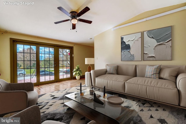 living room featuring lofted ceiling, ceiling fan, french doors, and wood finished floors