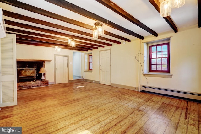 unfurnished living room with a baseboard heating unit, beamed ceiling, baseboards, and hardwood / wood-style flooring