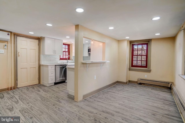 kitchen featuring a breakfast bar area, a baseboard radiator, light countertops, light wood-style flooring, and dishwasher