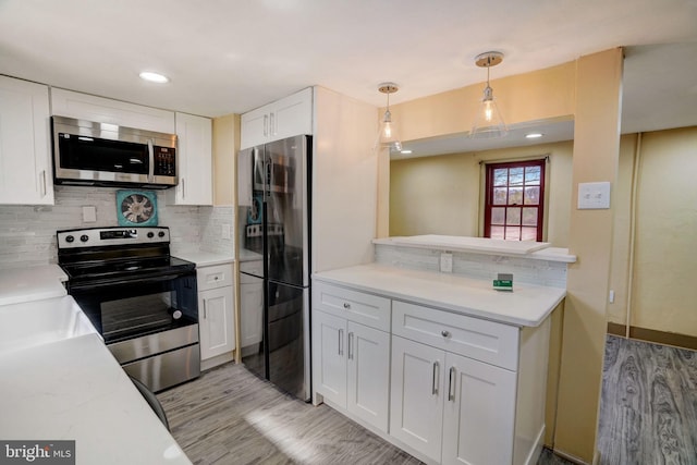 kitchen with light countertops, appliances with stainless steel finishes, backsplash, and white cabinets