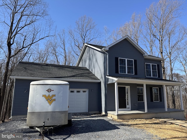 traditional-style house with an attached garage, driveway, and a porch