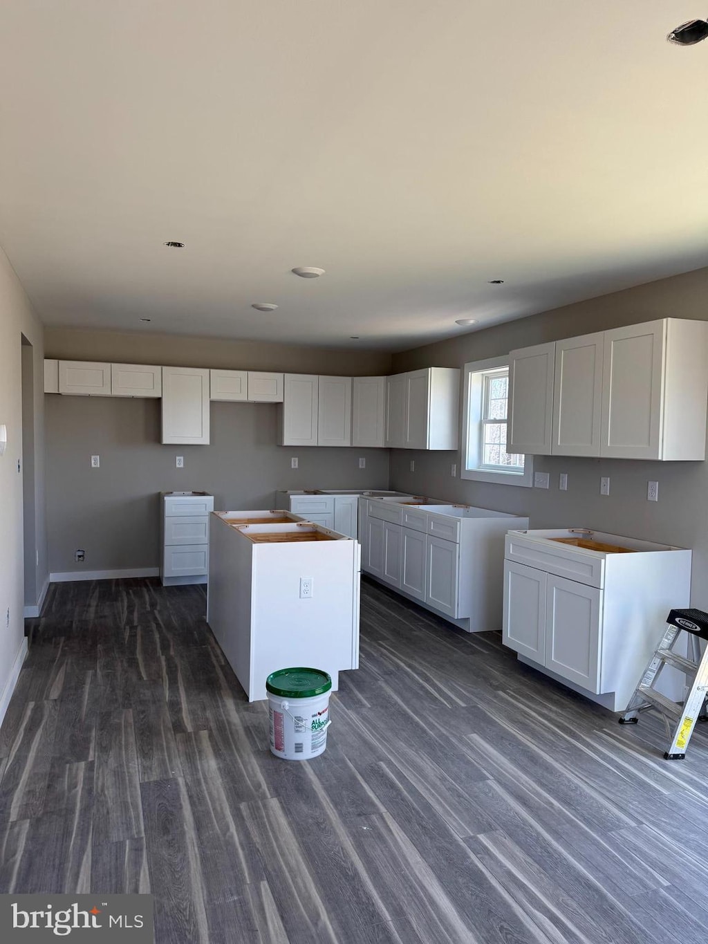 kitchen featuring a kitchen island, white cabinets, and dark wood-type flooring